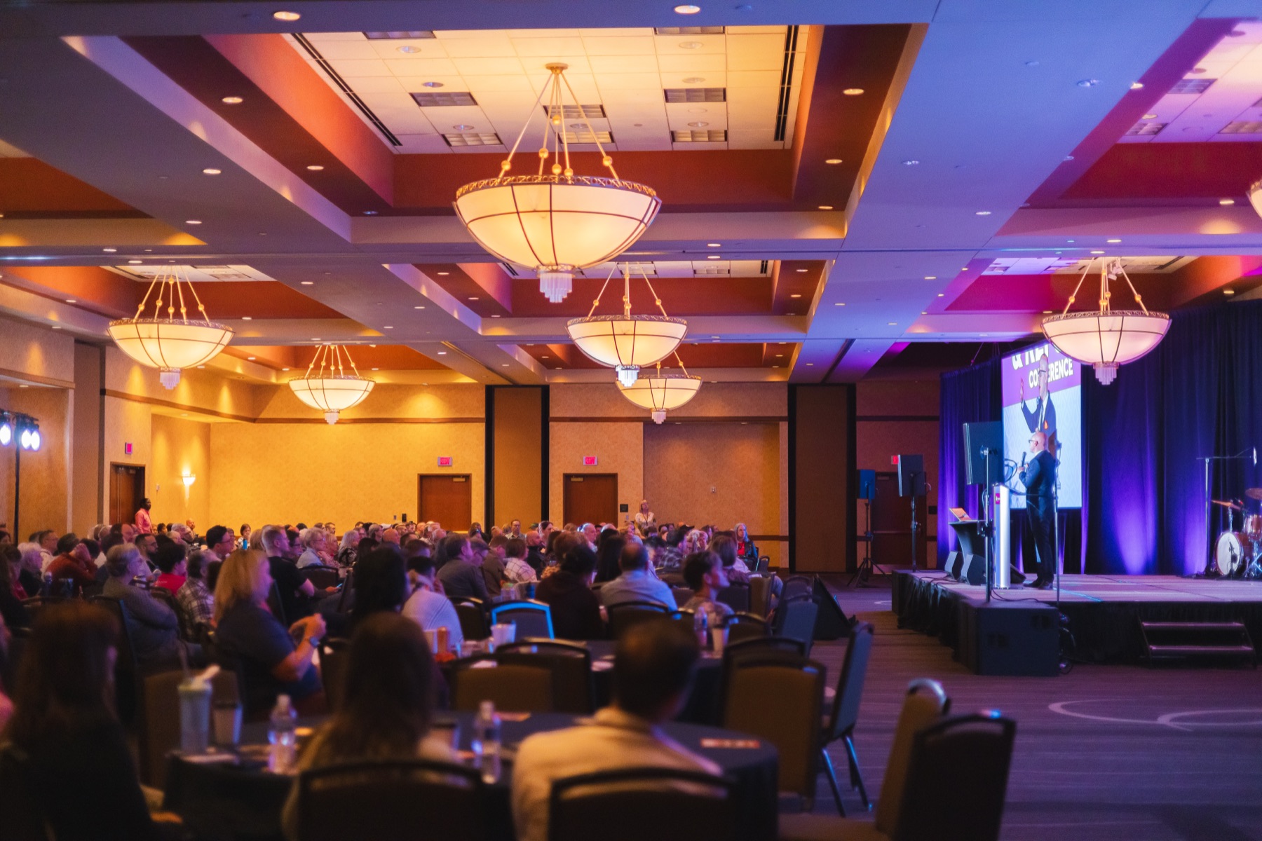 A full ballroom of attendees listening to a speaker at the 2023 Reconcile and Reform Conference