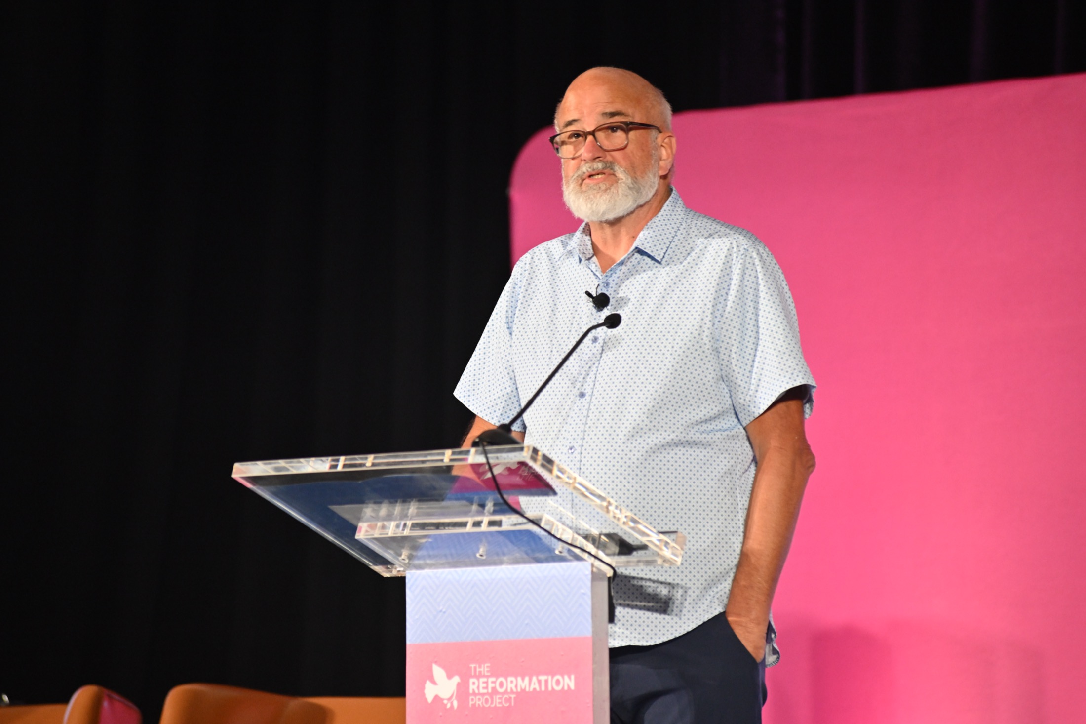 A speaker teaching from the podium at the 2025 Reconcile and Reform Conference